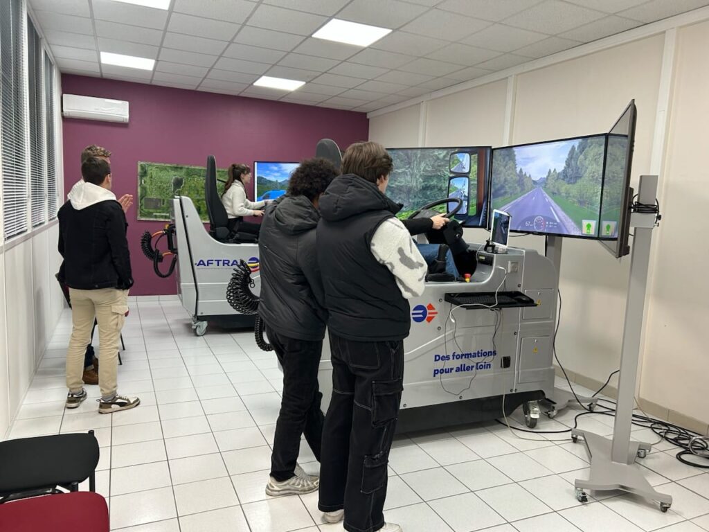 Des personnes utilisant des simulateurs de conduite dans une salle de formation.